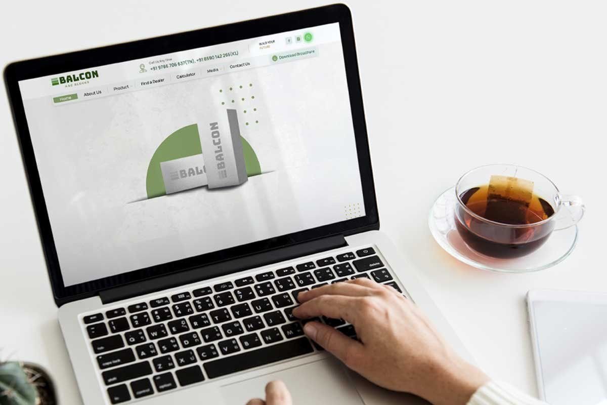 The Balcon AAC website on a laptop next to a cup of tea
